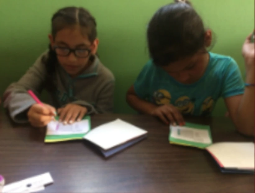 2 children reading at a table