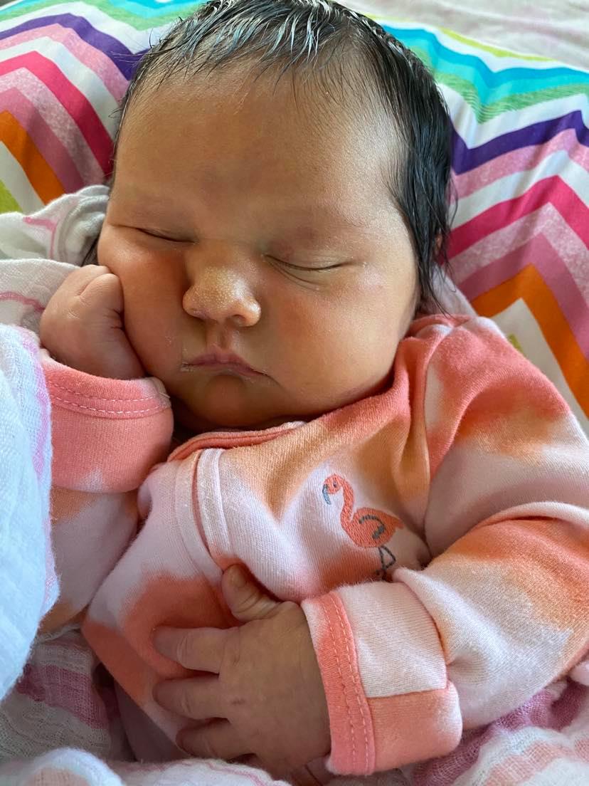 Baby girl sleeping with a hand on cheeck